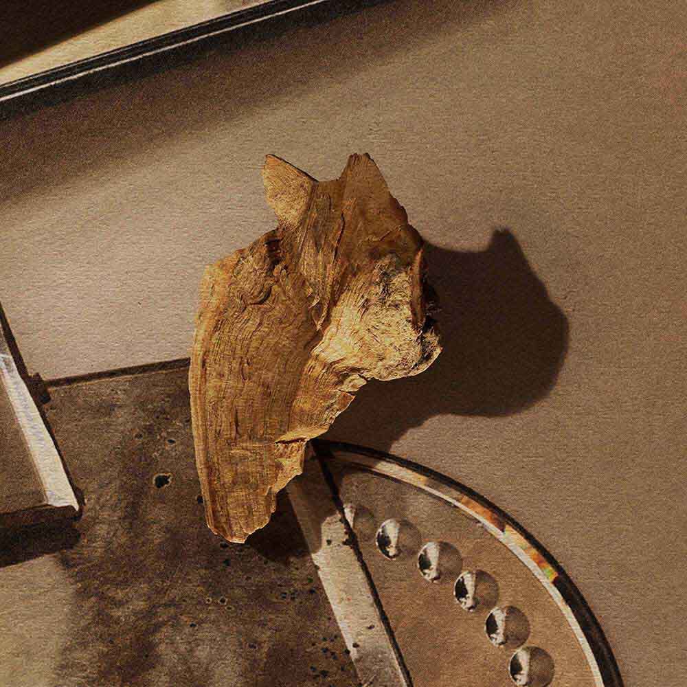 Piece of wood resting on stacked mirrored trays.