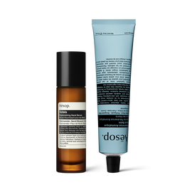 A pump bottle of Solais Replenishing Hand Serum and a tube of Reverence Aromatique Hand Balm together in a carboard box