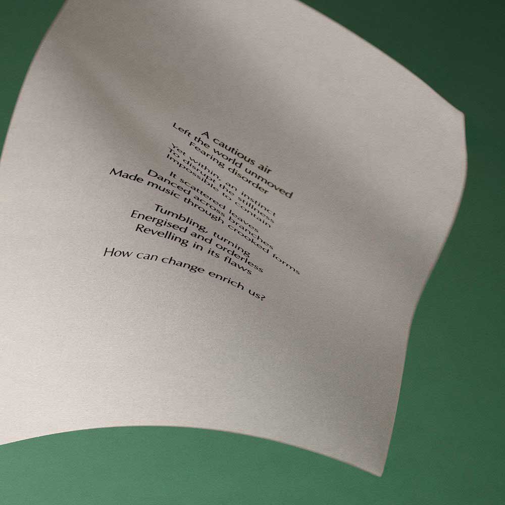 Curved cream page with printed verse against a dark brown background.