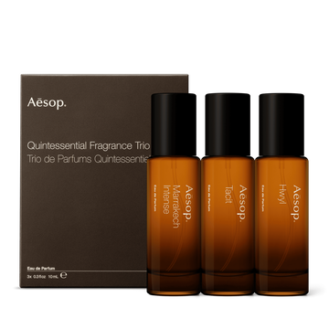Three amber glass fragrance bottles, alongside a cardboard gift box with pull out sleeve. 