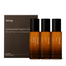 Three amber glass fragrance bottles, alongside a cardboard gift box with pull out sleeve.