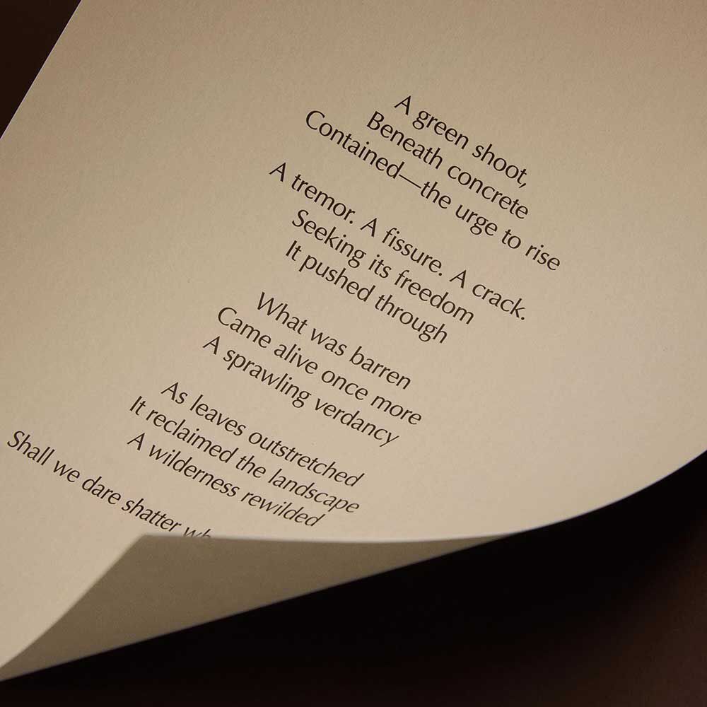 Curved cream page with printed verse against a dark brown background.